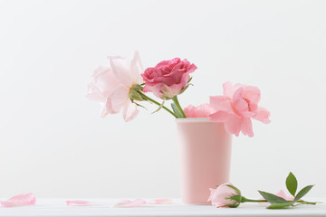 Fototapeta na wymiar Pink roses in vase on white background