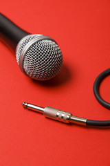 microphone and lead on a bright red background.