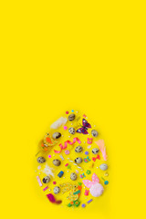 Quail eggs and decoration, in egg shape, on yellow background with copy space; easter background