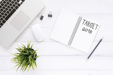 Minimal work space - Creative flat lay photo of workspace desk with Target 2018 New Year list notebook and laptop on wooden background. Top view flat lay photography. 2018 happy new year concept.