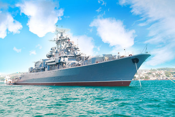 Obraz premium Military navy ship in the bay with blue sky and clouds