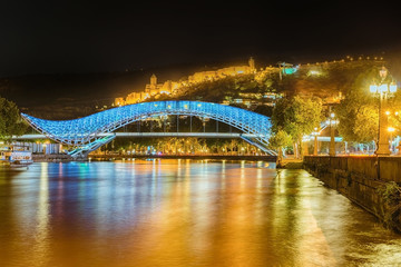 Naklejka premium Narikala Fortress and illuminated Bridge of Peace across Kura river, Tbilisi, Georgia.