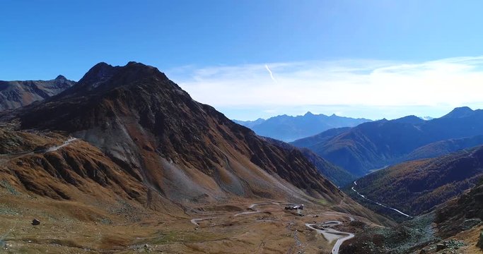 Mountain valley, Cinema 4k tilt view of a curvy road, in a valley full of harsh nature between alps, on a sunny autumn october day, on grand san bernardo pass, in switzerland