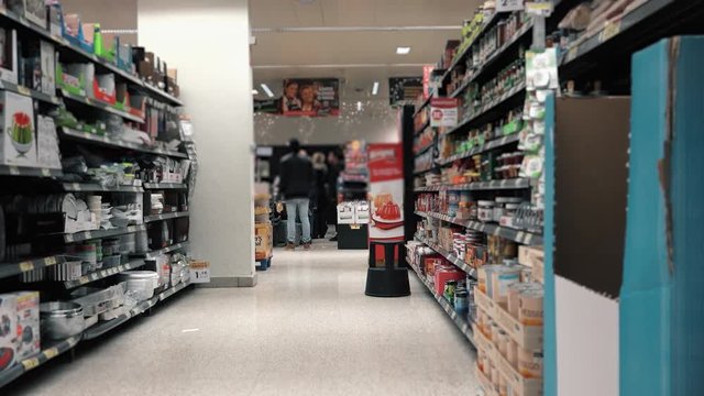 Supermarket Aisle With People In Cashier. Empty supermarket aisle with people paying the cashiers