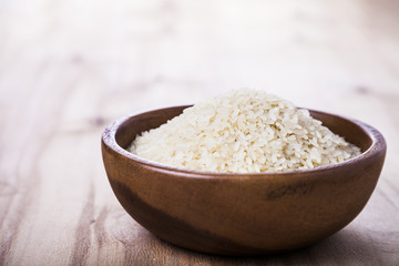 Raw rice in a wooden bowl