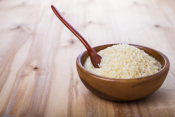 Raw rice in a wooden bowl