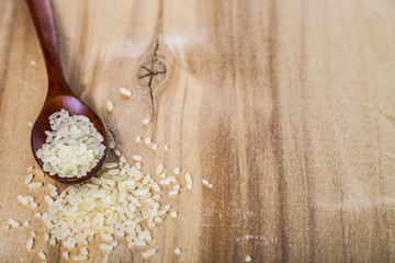 Raw rice in a wooden spoon