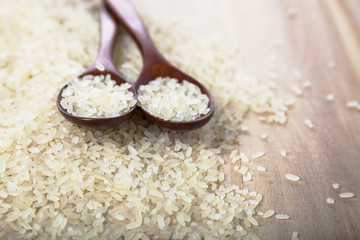 Raw rice in a wooden spoon