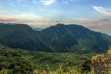 Sunrise in meadows and mountains landscape, Worlds End in Horton Plains National Park Sri Lanka.