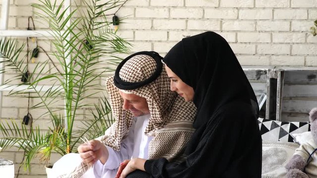 Young arab muslim family with pregnant wife expecting baby