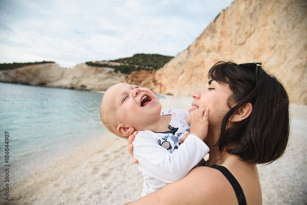 Poster mother holding son on beach