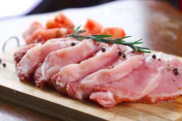 Slices of meat being seasoned for preparation.