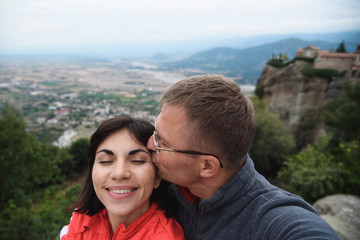 Man Kissing Woman and Making Selfie