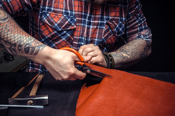 Man working with leather using crafting scissors
