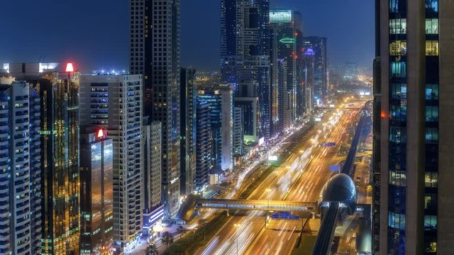 Spectacular nighttime skyline of Dubai. UAE. Aerial view of skyscrapers, highways and metro station. 4K time lapse. Colourful travel background. 