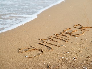 Message summer and foot painting  on sand beach.