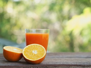 Fresh orange juice and fresh oranges  on wooden table.