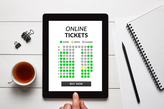 Online tickets concept on tablet screen with office objects on white wooden table. All screen content is designed by me. Flat lay