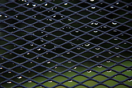 Garden furniture sprinkled with rain drops. A gloomy day in a country house garden. Abstract still life.