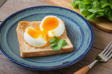 Fototapeta premium Soft boiled egg with toast on blue plate