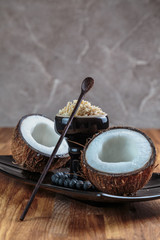 Shisha coconut in glossy black cup on a plate with opened coconut