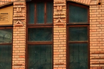 Fototapeta na wymiar Close-up of old window in a red brick building facade