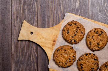 Homemade oatmeal cookies on a wooden cutting Board. Wooden background