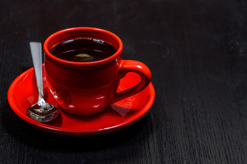coffee in a red mug on a black wooden background