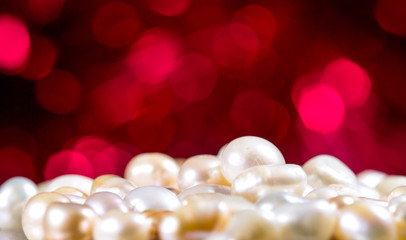 White pearls on red glitter background close up macro.