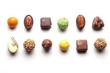 Various chocolate pralines isolated on white background. Top view. - obrazy, fototapety, plakaty