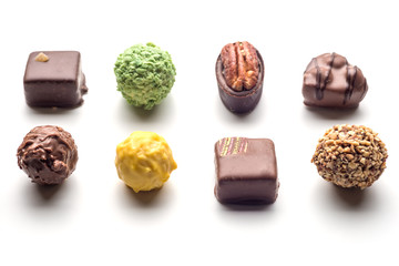 Various chocolate pralines isolated on white background. Top view.