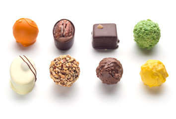 Various chocolate pralines isolated on white background. Top view.