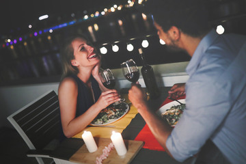 Young beautiful couple having romantic dinner on rooftop