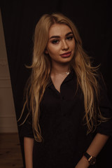 Perfect skin. Portrait of blond woman with opening eyes and strong face and standing against grunge background