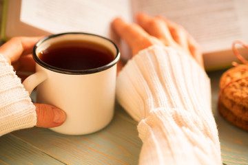 Girl reading book and drinking tea in winter