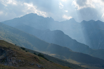 Mountains range with stormy sky and sunbeam