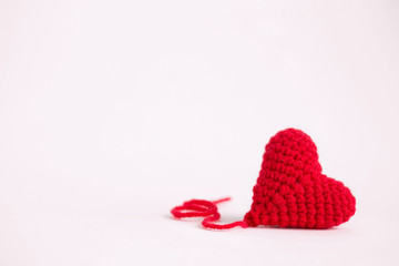 red crochet heart on pink background. Valentine's Day. Symbol of love.