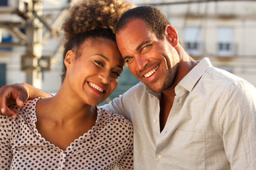 happy man and woman standing together in city on date