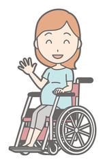 A pregnant woman in green's clothes is on a wheelchair with a smile