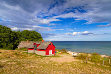 Fototapeta na wymiar Red cottage house at the beach of Baltic sea in Sweden