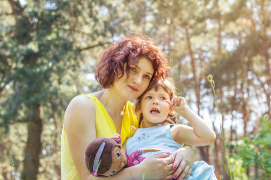 Young mother and little daughter playing in the park on a summer sunny day