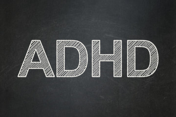 Health concept: text ADHD on Black chalkboard background