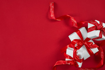 White gift boxes with red ribbon on red background. Valentines d