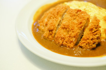 Spicy crispy pork cutlet omelet curry serve on white dish for Japanese or asian food background or texture.