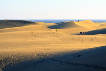 Fototapeta na wymiar Tourists on dunes in Maspalomas the Gran Canaria island.