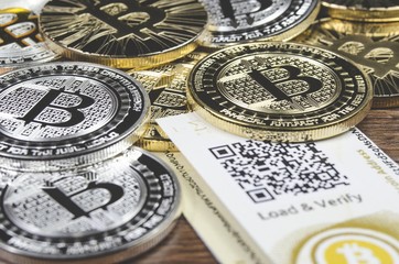 Fototapeta na wymiar Bitcoin coins laying on paper wallet with QR code for contactless payment