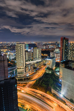 Night scape of Damansara city with the moving cloud and light trail from vehicles and skyscrapers as background while waiting new year celebration.
