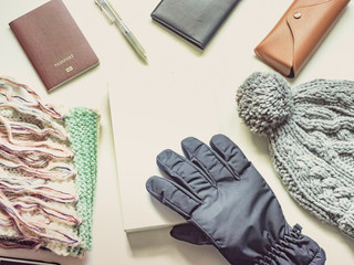 writer in holiday and winter season travel flat lay concept from  winter cloth item and passport, sunglasses with copy space and isolated white background
