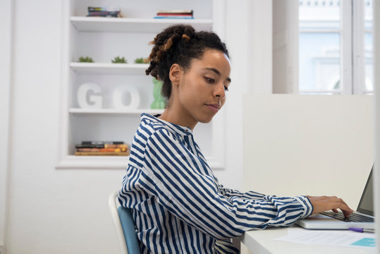 Businesswoman typing on laptop at office desk