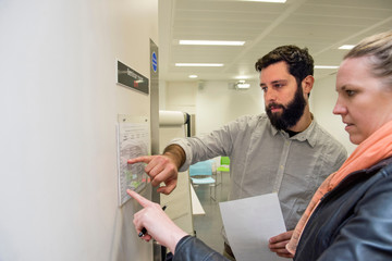 Tutor and student looking at timetable on seminar room door